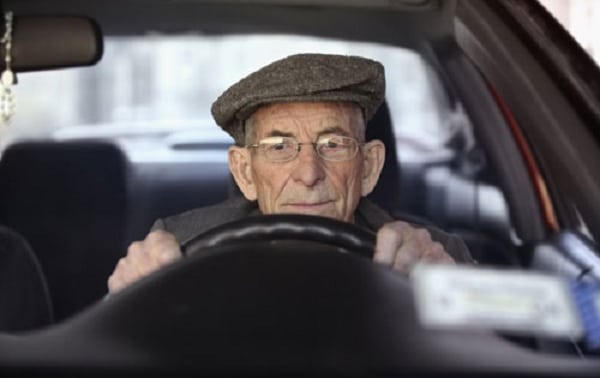 elder man in car driving